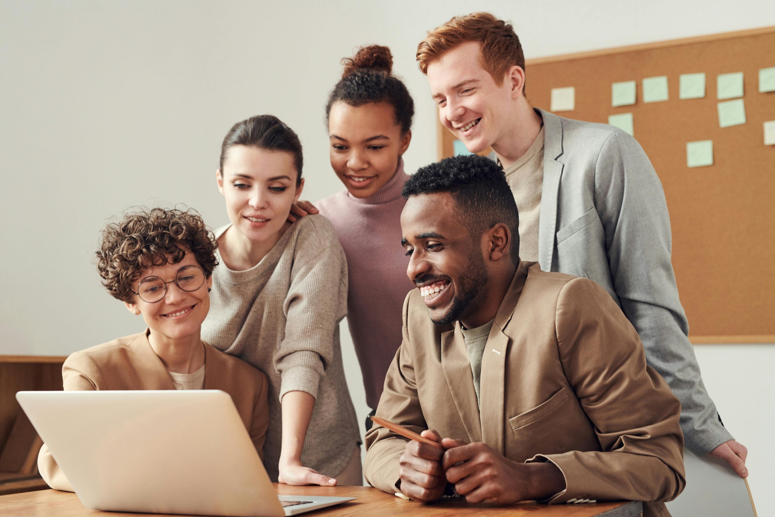 pexels-photo-3182812-3182812 A group of diverse young professionals happily collaborating around a laptop indoors.